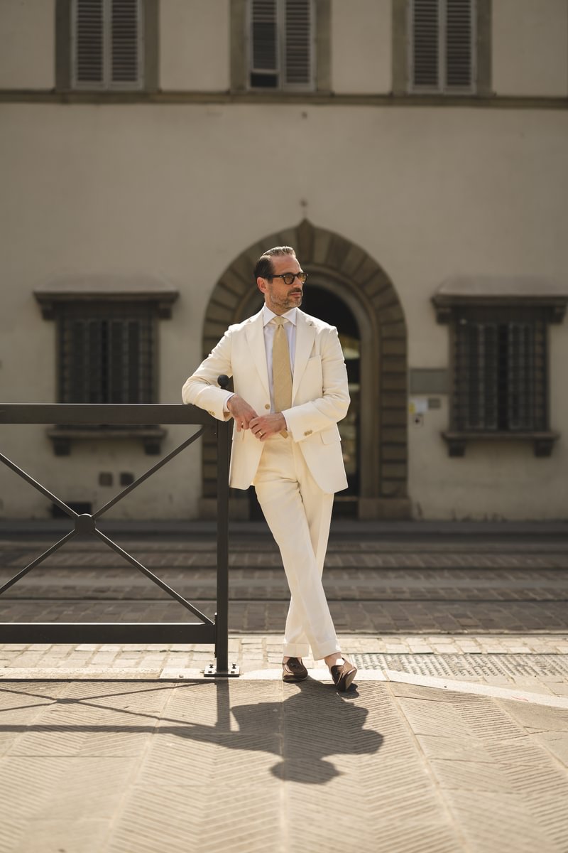 Brian wearing a cream linen suit with a white shirt and beige tie, styled with sunglasses and loafers - custom suits nyc bespoke tailor midtown, noho